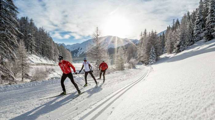 Three people cross country skiing