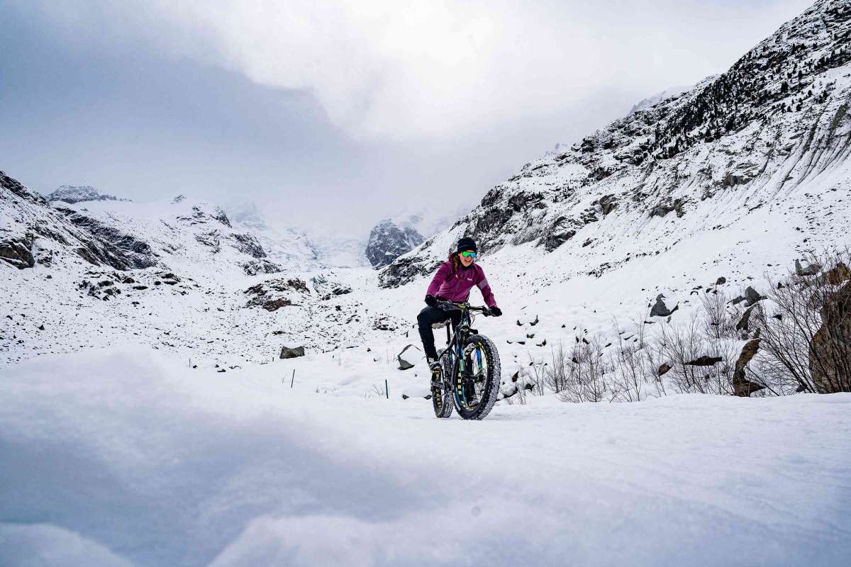 Woman cycling in snowy mountains