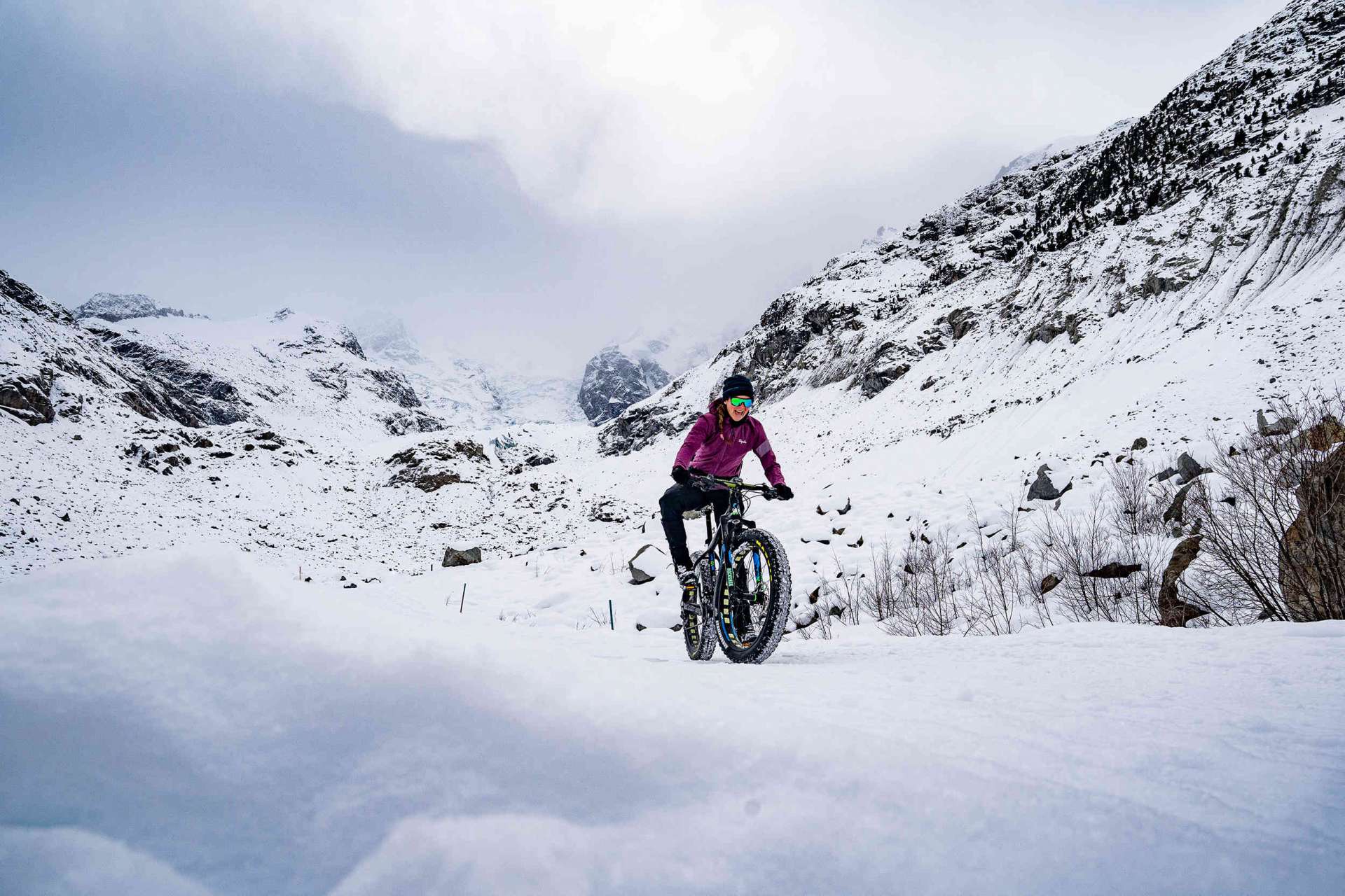 Woman cycling in snowy mountains