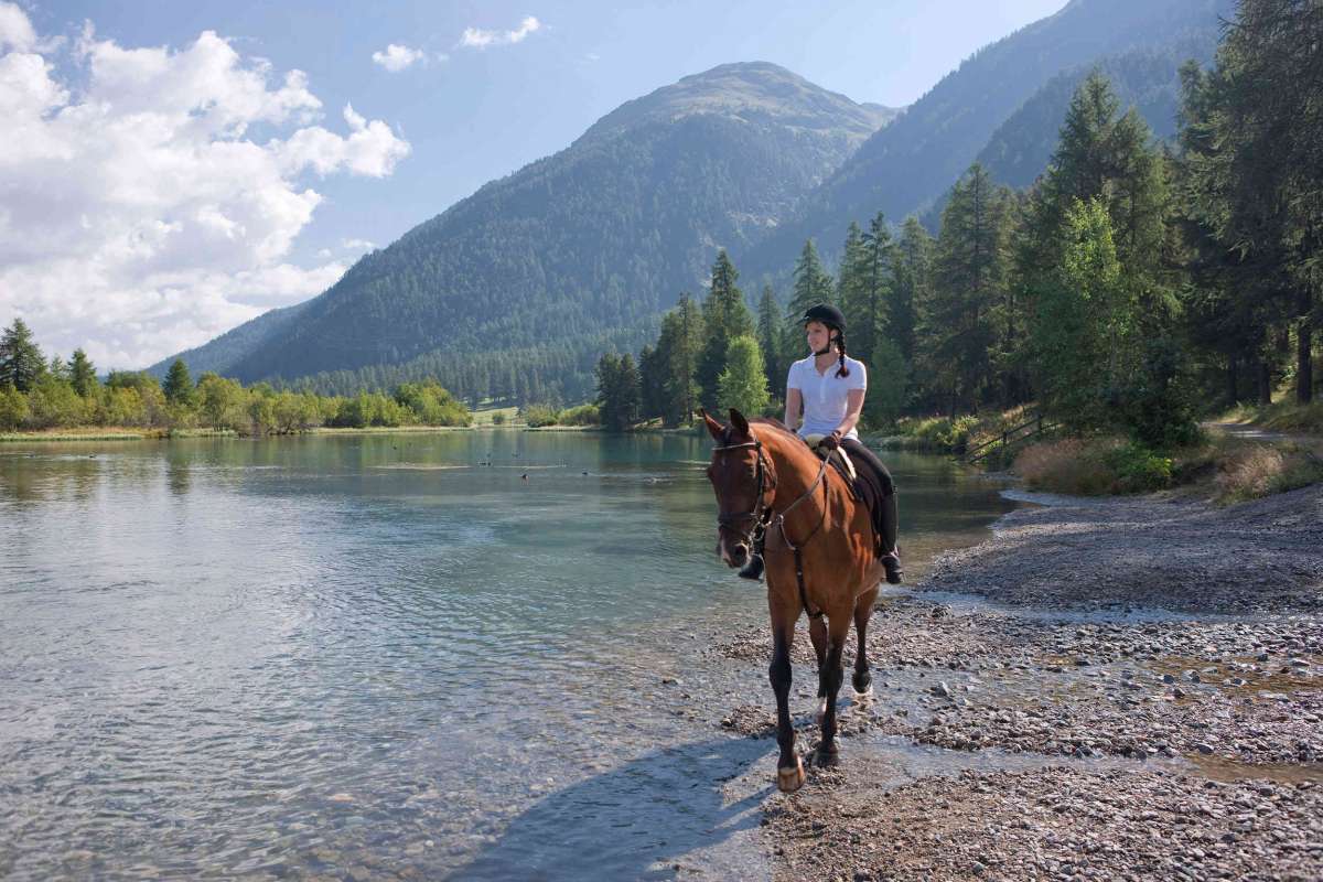 Horse riding through water in the Engadin