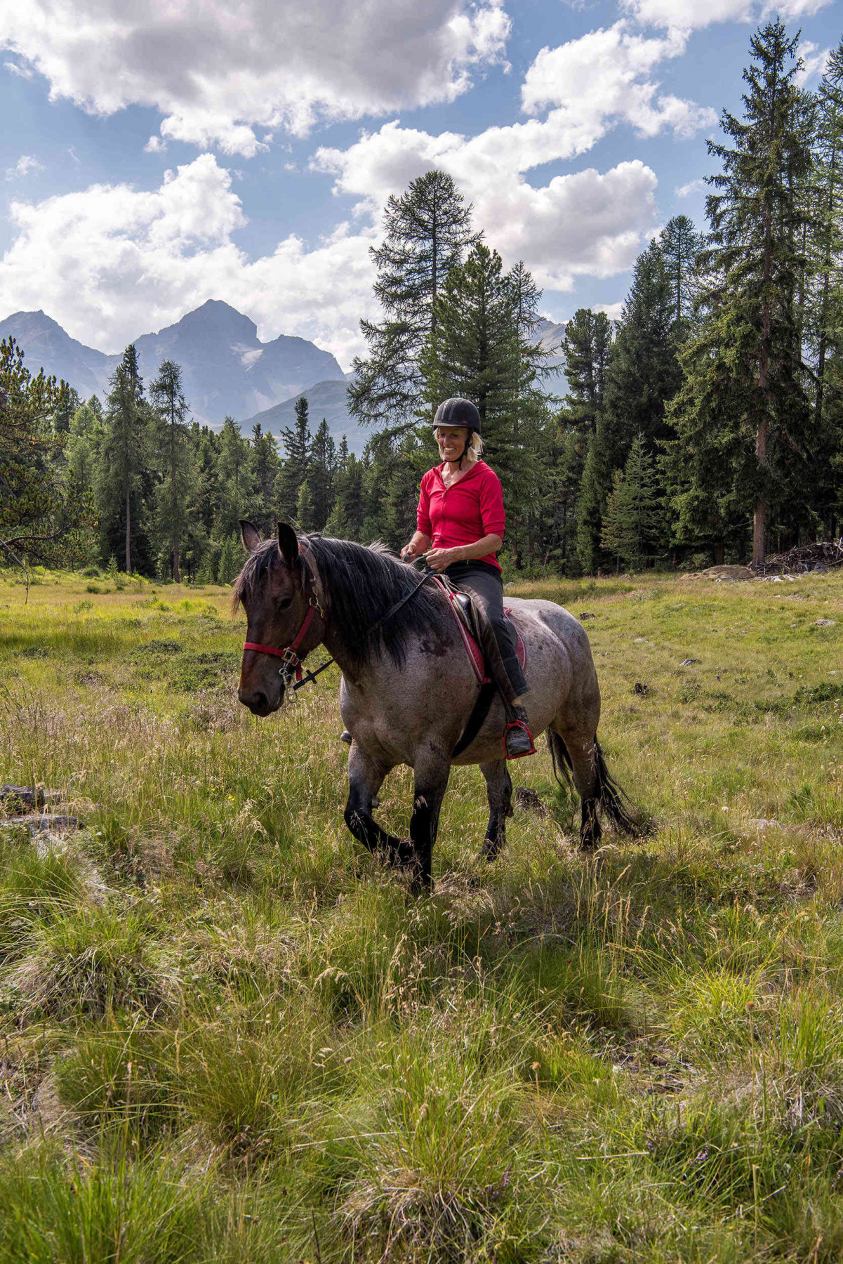 A woman horseriding in the Swiss Alps
