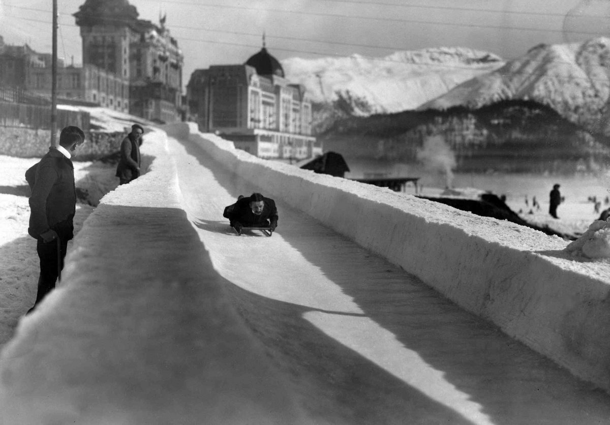 Black and white image of someone toboganning down the Cresta Run in St. Moritz in 1914