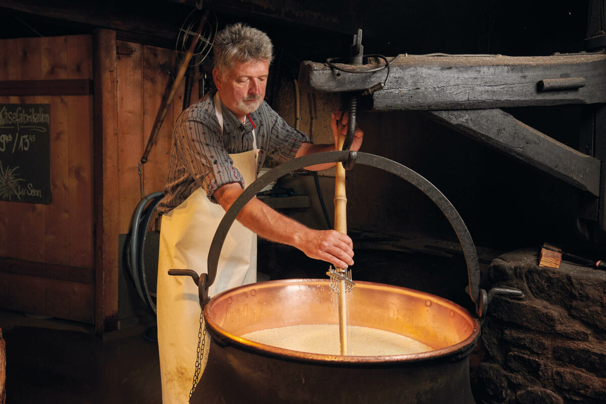 A cheesemaker demonstrates the process of turning milk at  Sennerei Pontresina,  Engadin, Switzerland