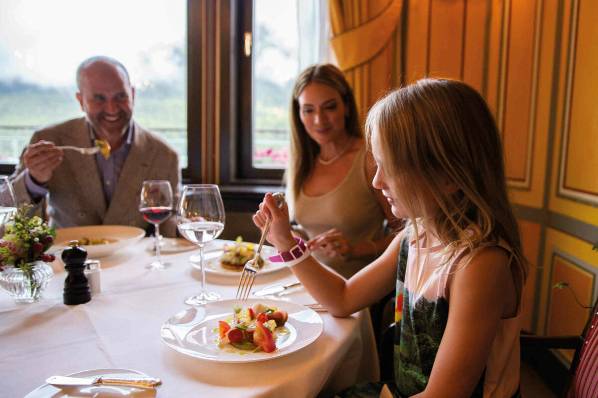 A couple and their daughter enjoying a meal at a restaurant 