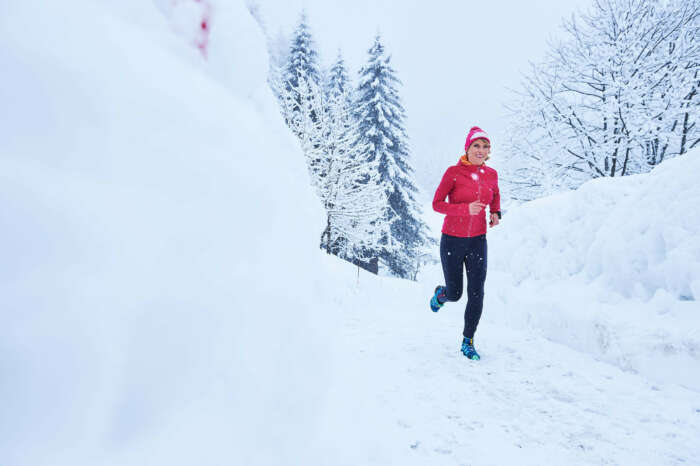 Läuferin auf einem tiefverschneiten Pfad, Schweiz
