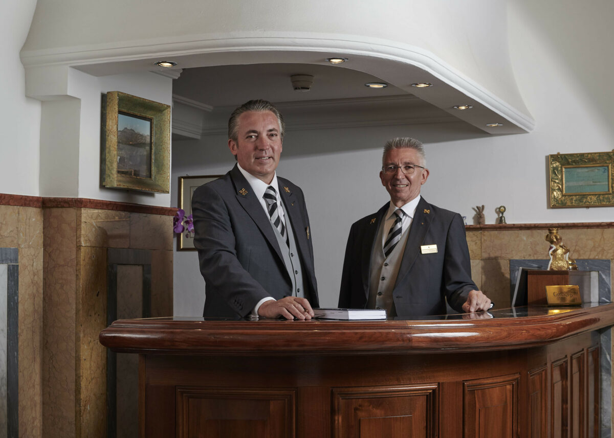 Two hotel concierges smiling