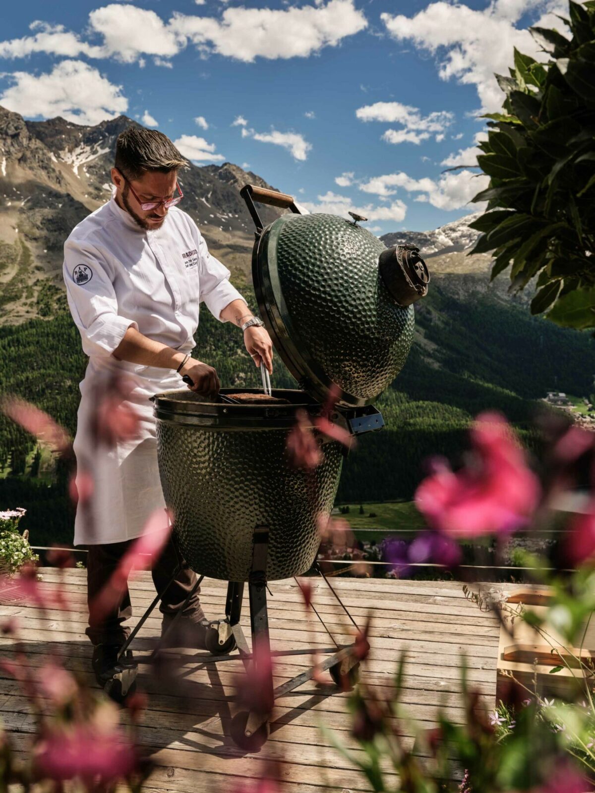 Chef barbecuing with mountains in the background