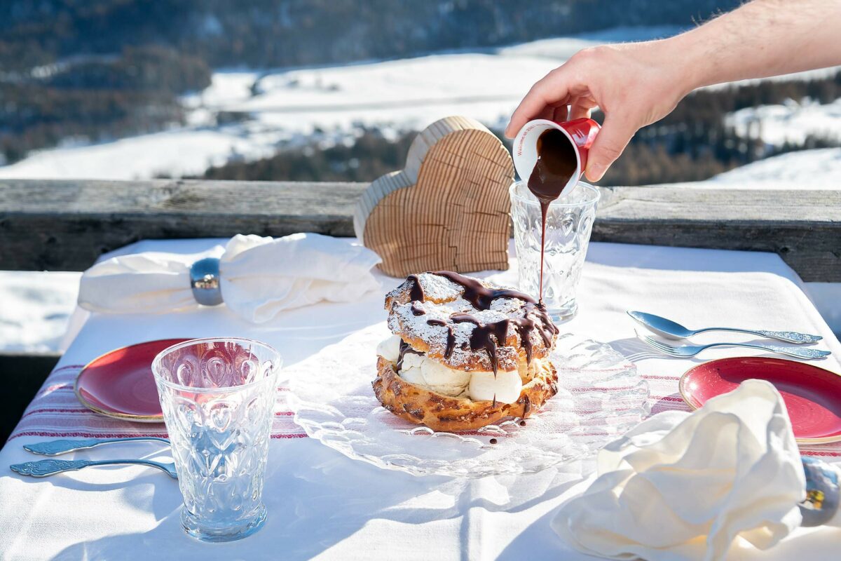 Melted chocolate being dribbled over giant profiterole