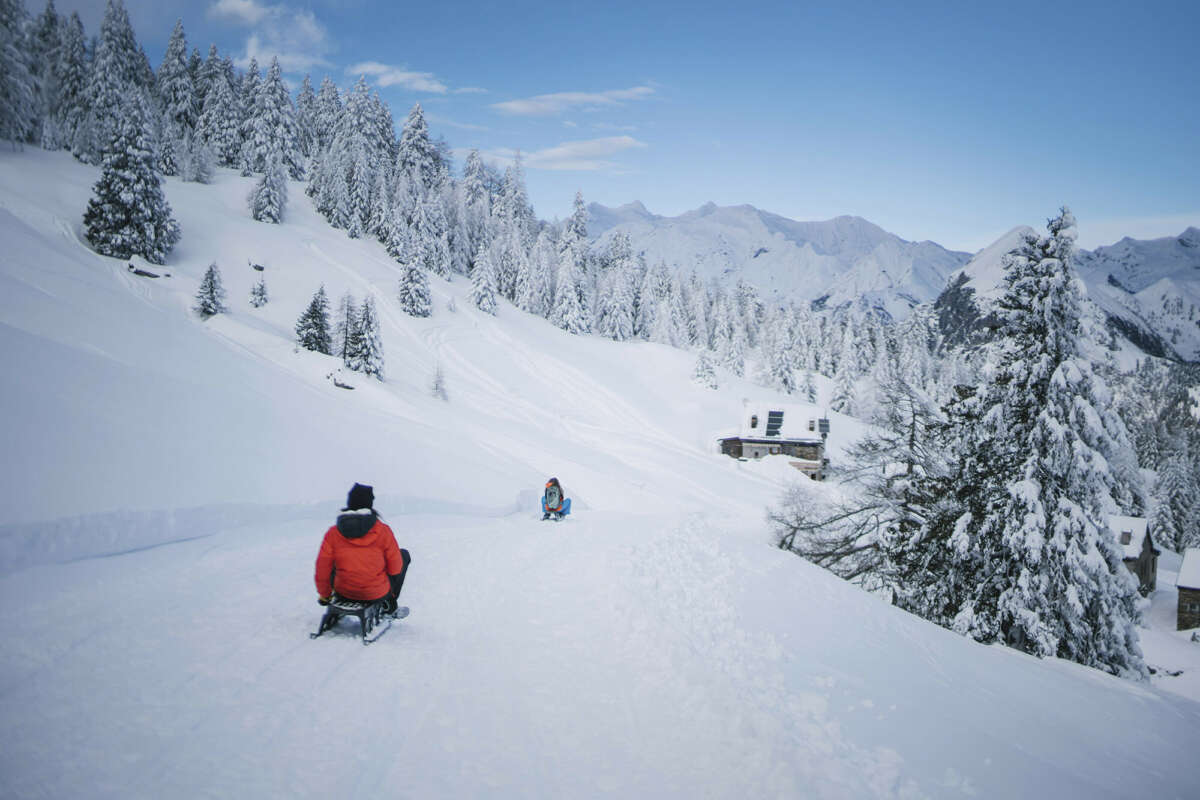 Sledging down a mountain surrounded by beautiful scenery