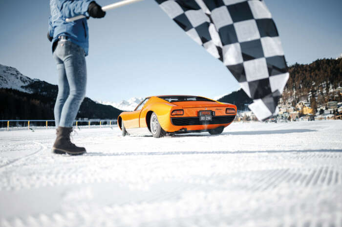 Black and white racing flag and classic car driving on snow