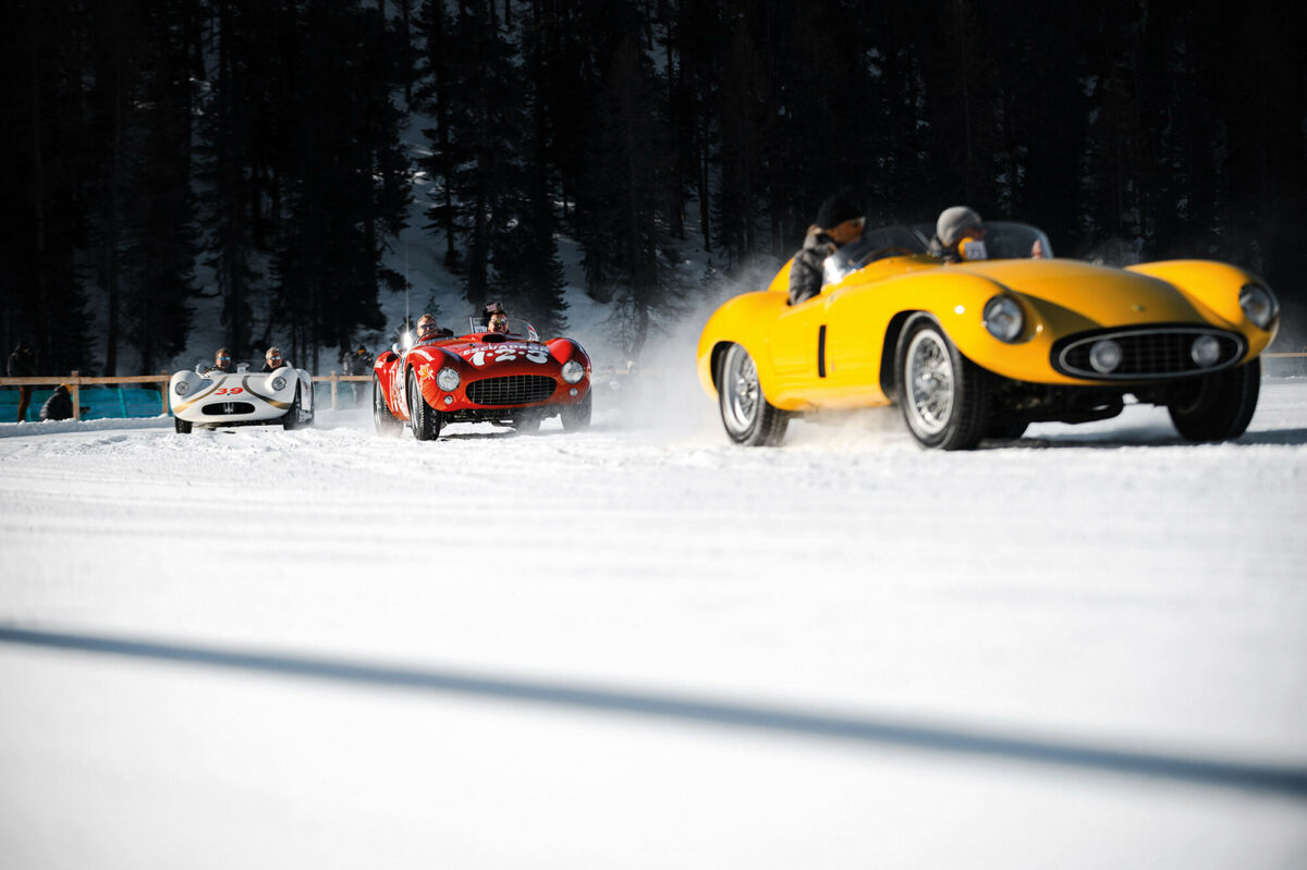 Three classic cars racing on snow