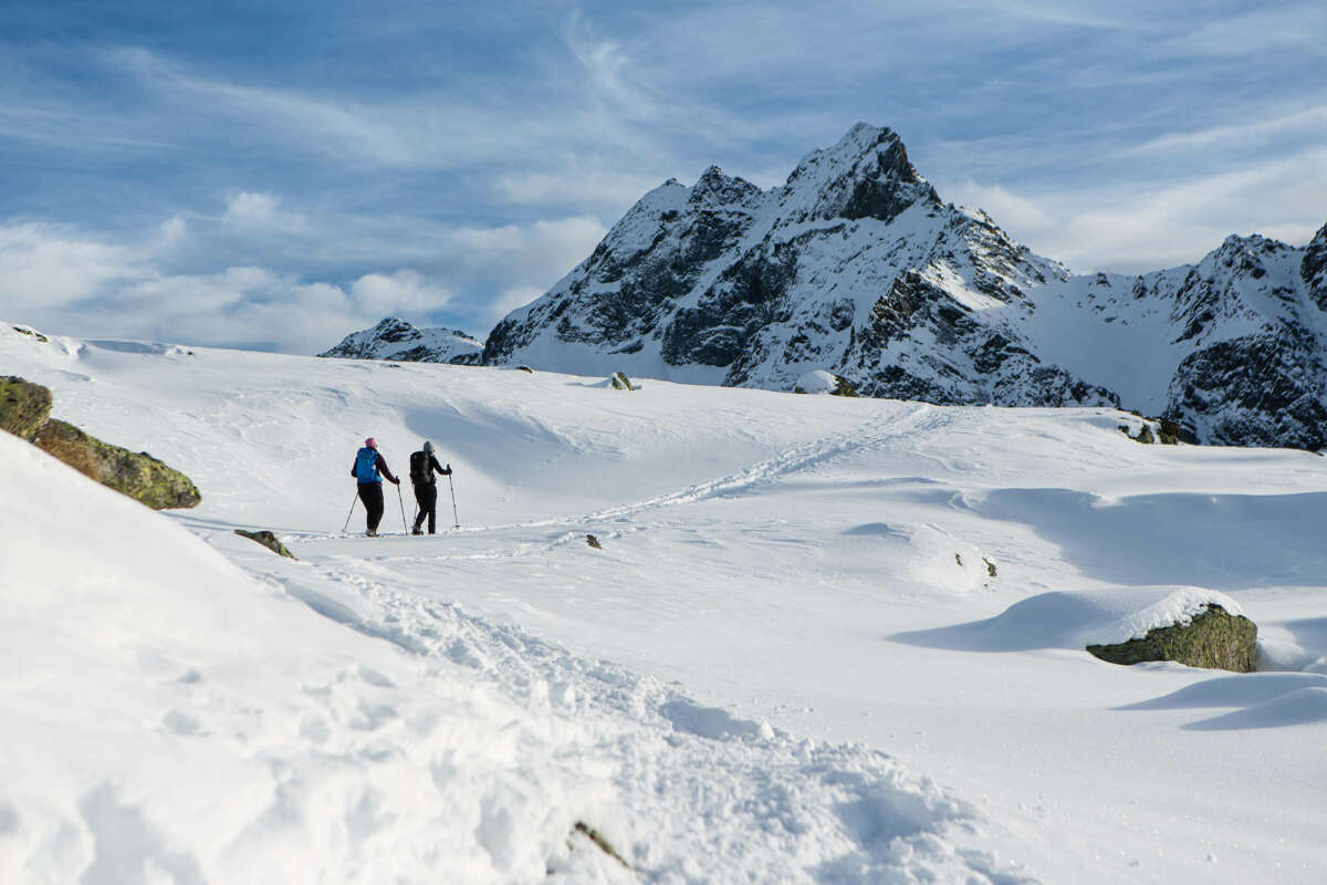 Two people snowshoeing in the mountains