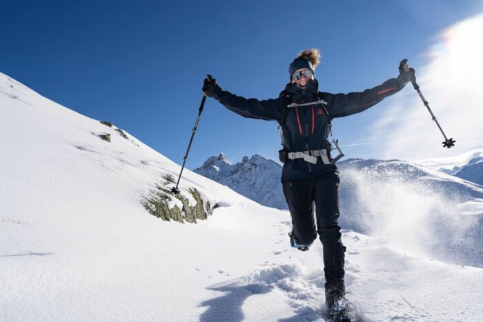 Glückliche Frau beim Schneeschuhwandern in den Bergen