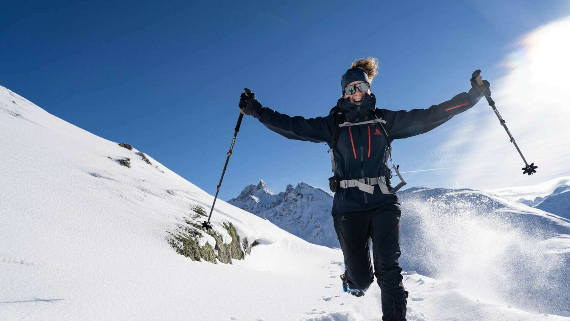 Glückliche Frau beim Schneeschuhwandern in den Bergen