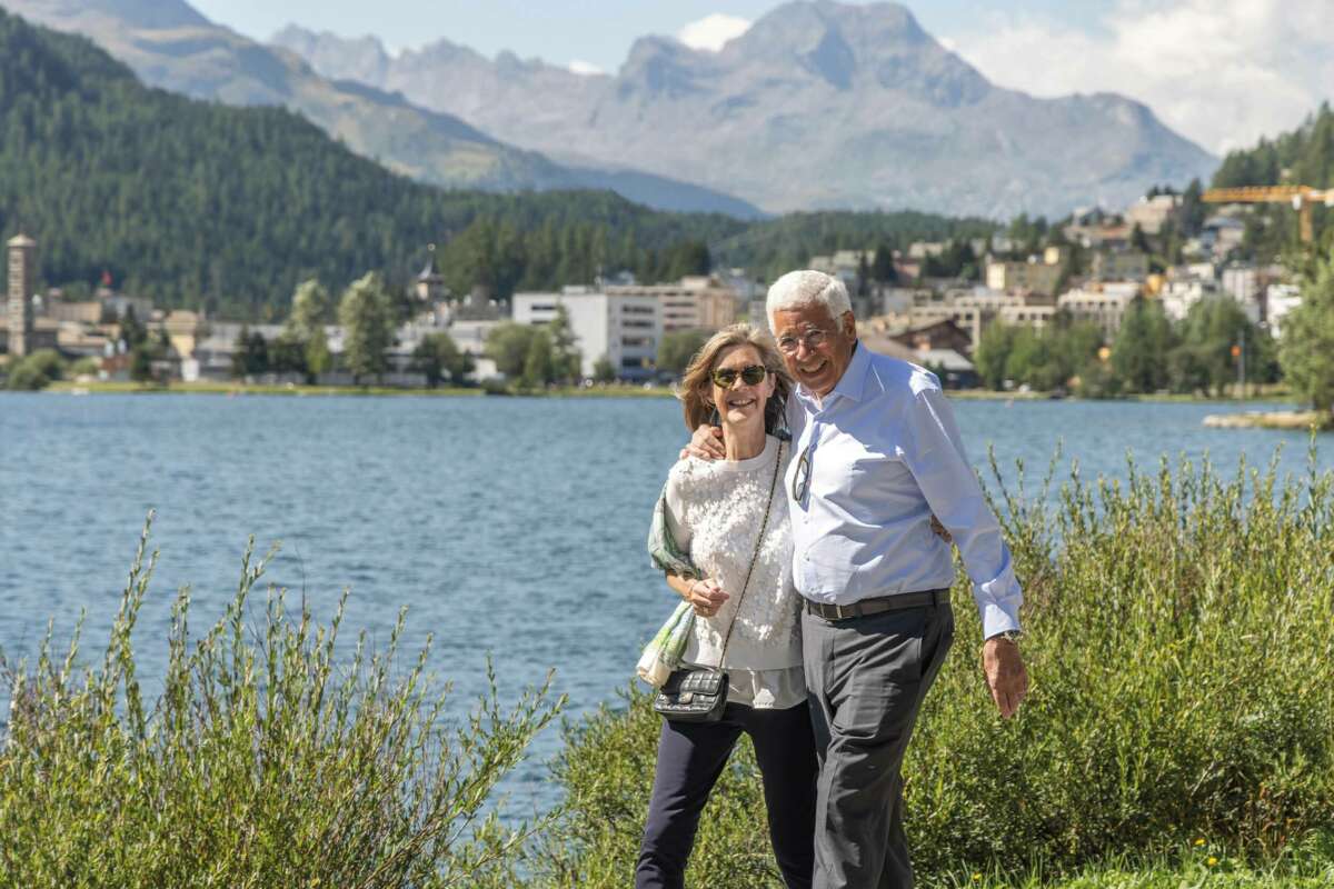 A couple enjoy a lakeside walk in St. Moritz