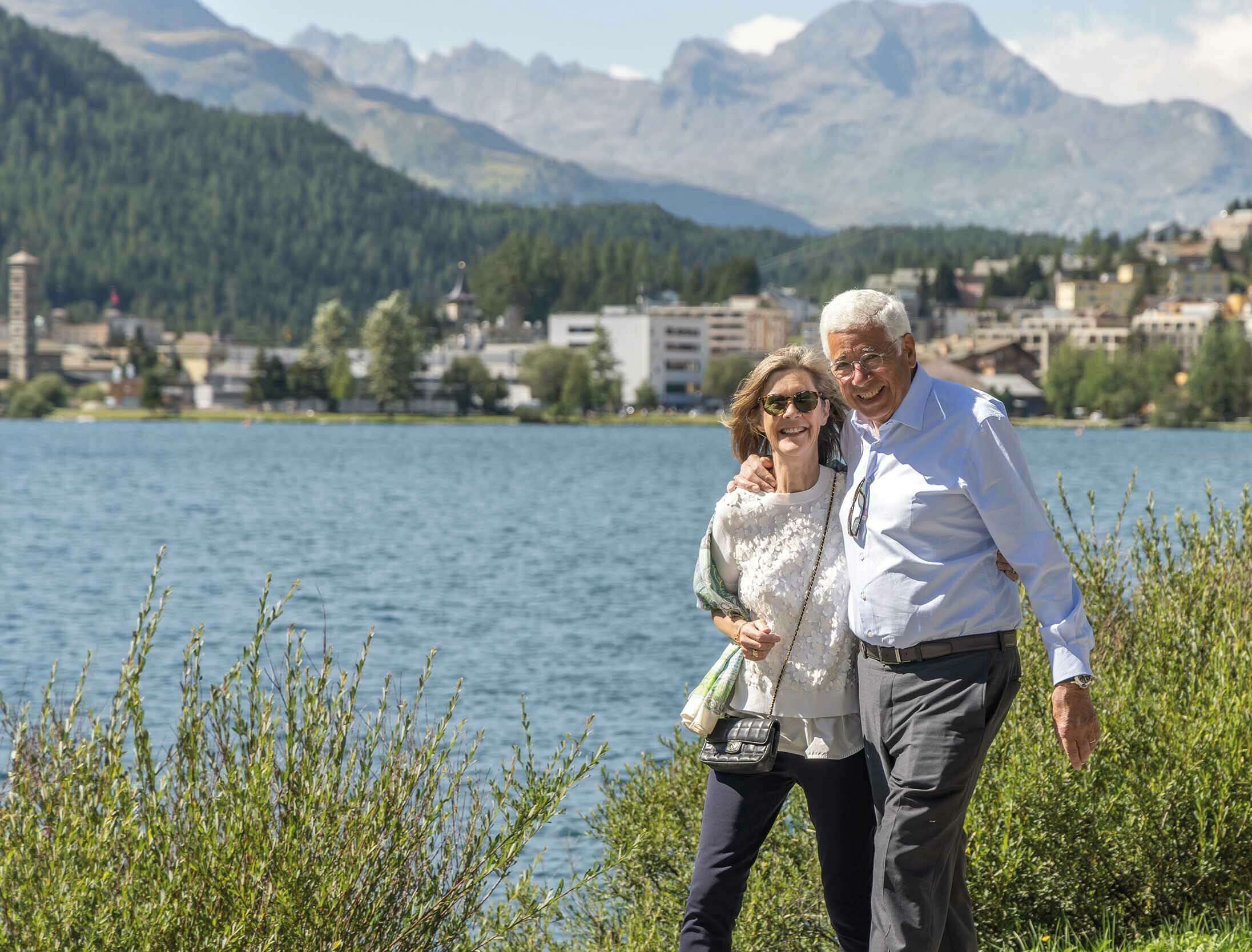 A couple enjoy a lakeside walk in St. Moritz
