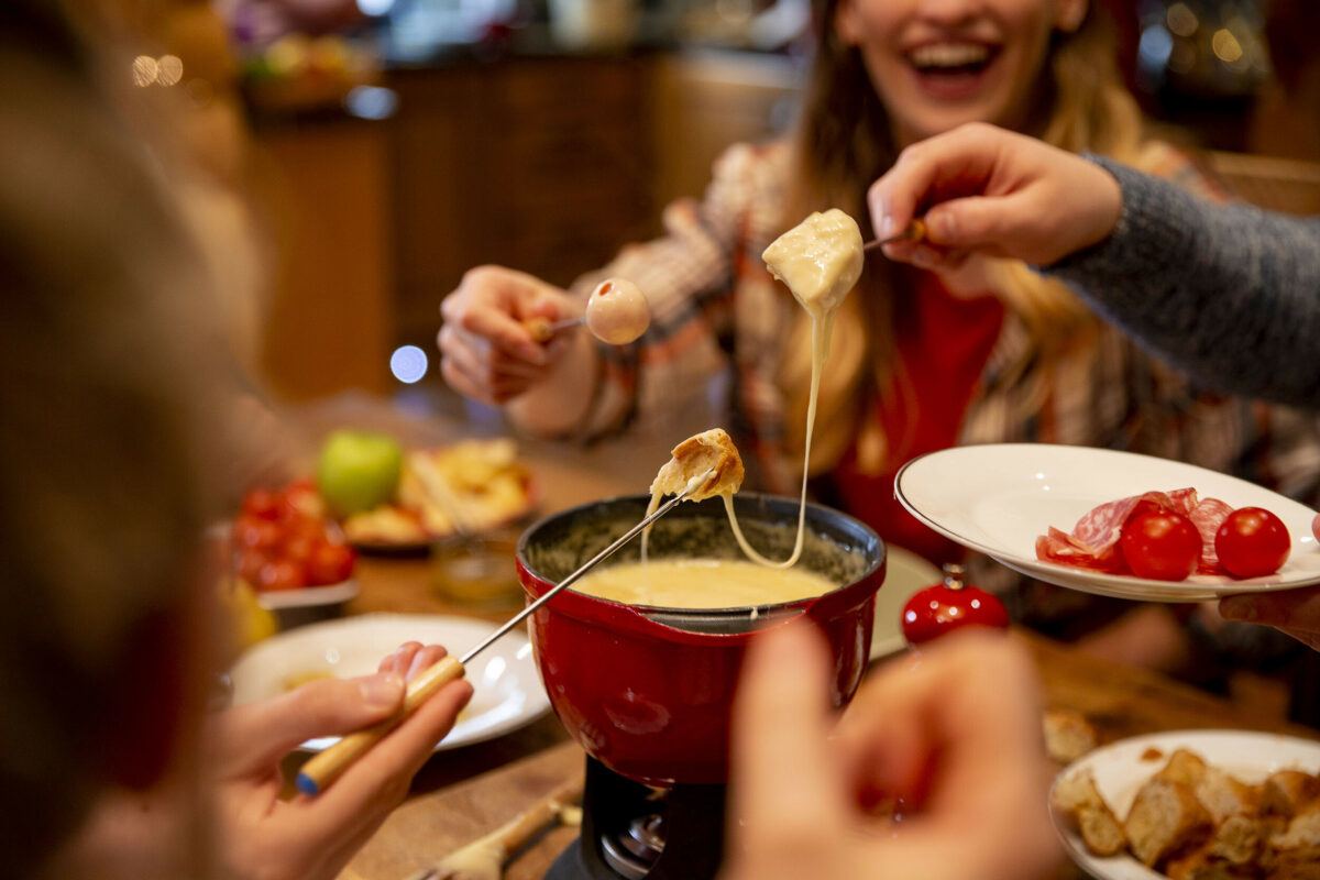 Eine Gruppe beim vergnüglichen Fondue zuhause
