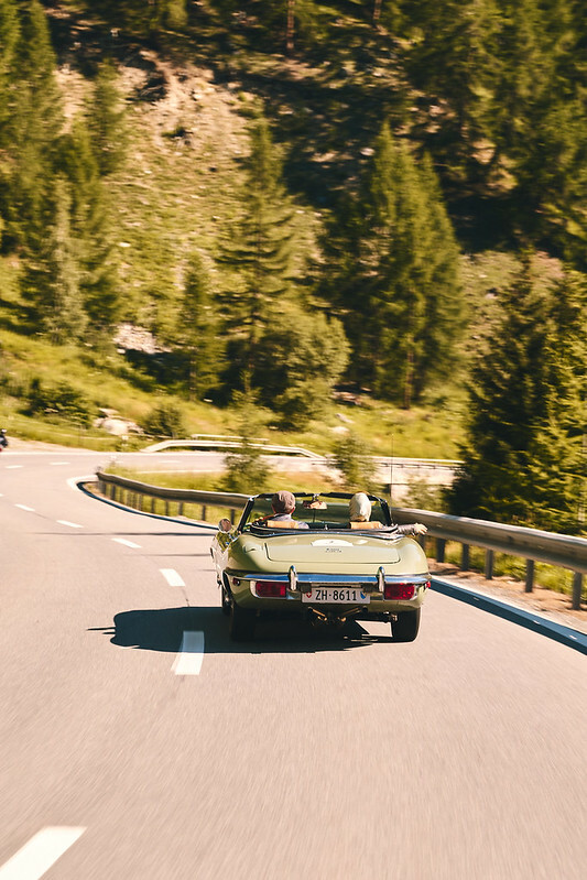 Couple driving a classic car on a mountain road