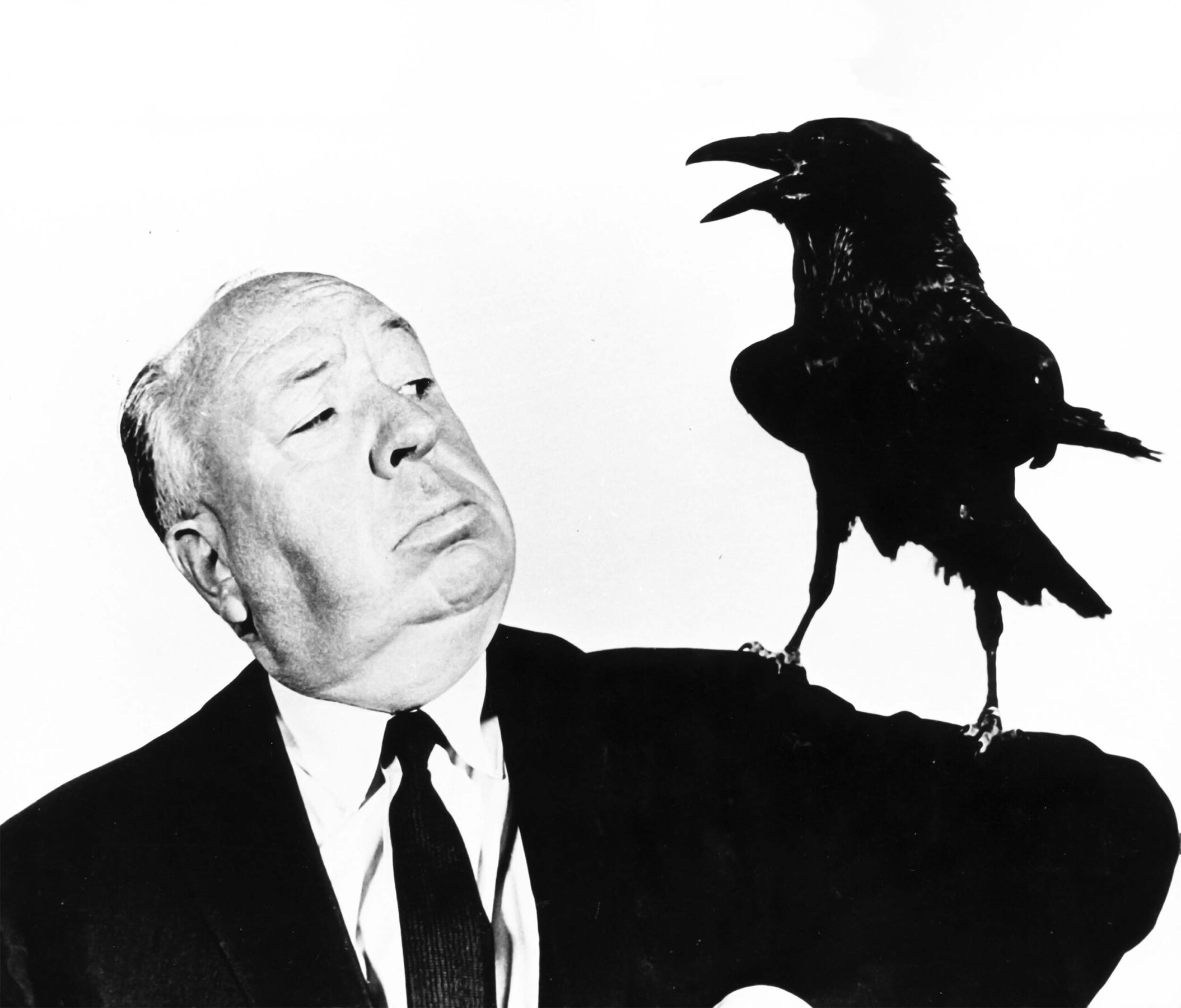 Schwarz-weißes Bild eines Mannes mit einer Krähe auf seiner Schulter