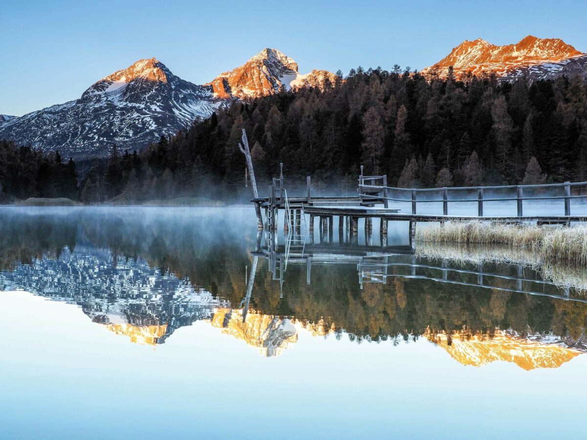 Lake in autumn with mist and reflections of mountains