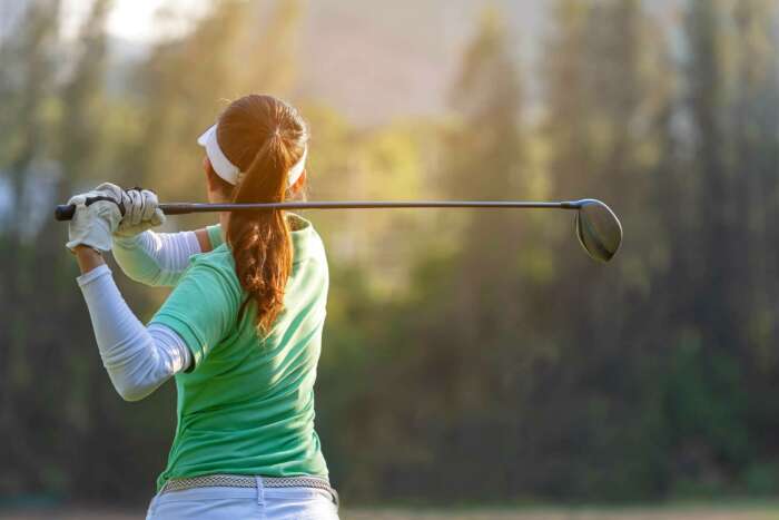 A woman golfer hitting the ball