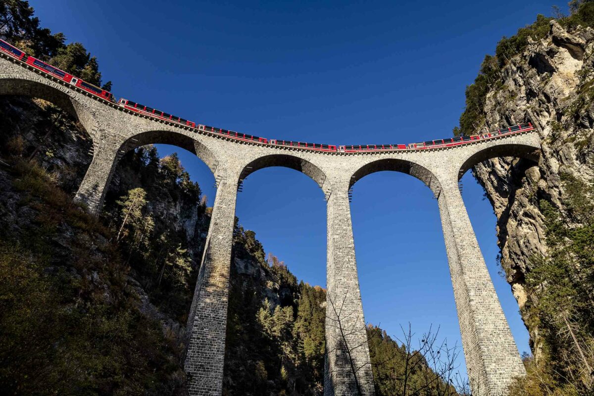 A train on a viaduct in the mountains