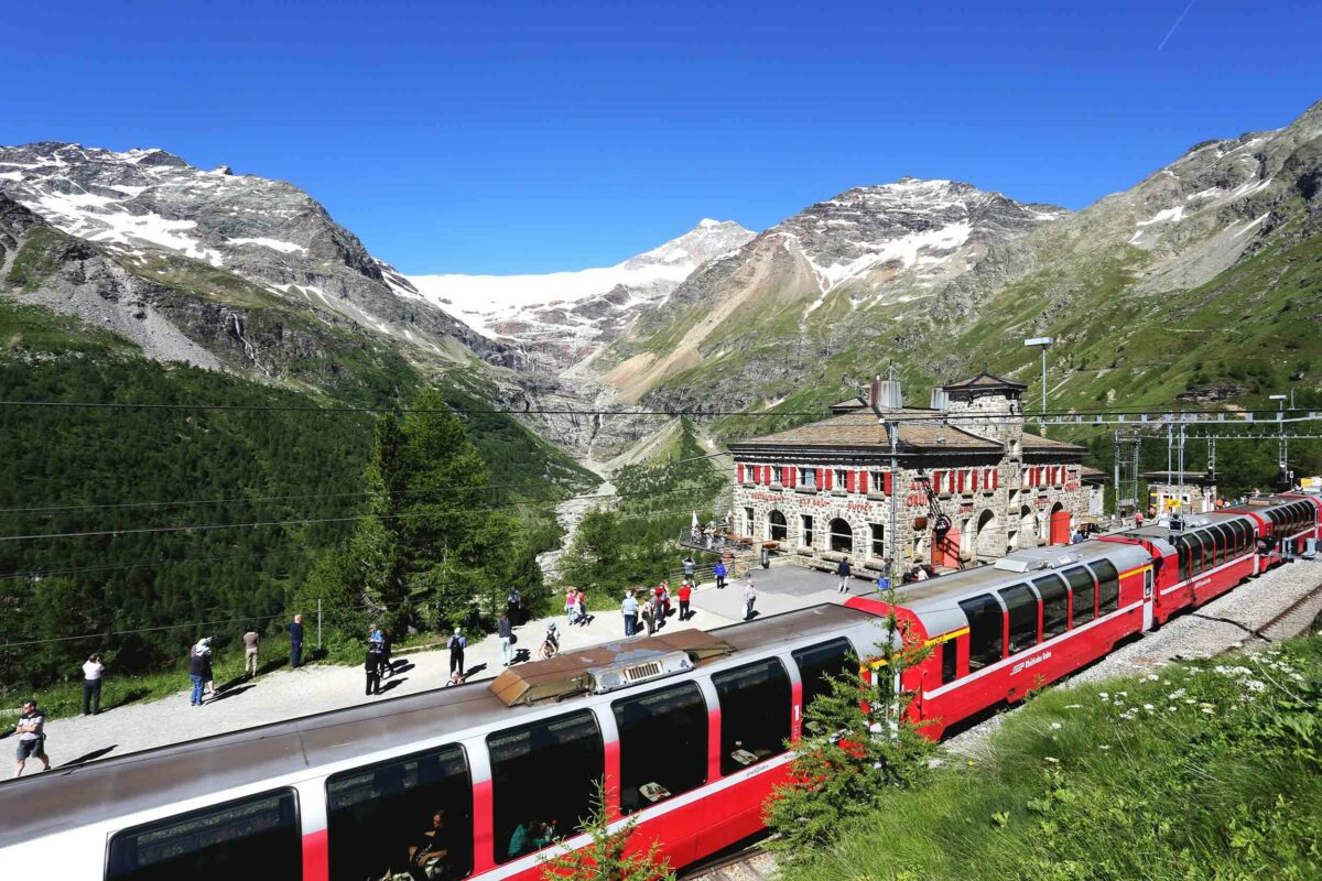 A train stopping at a station in the mountains