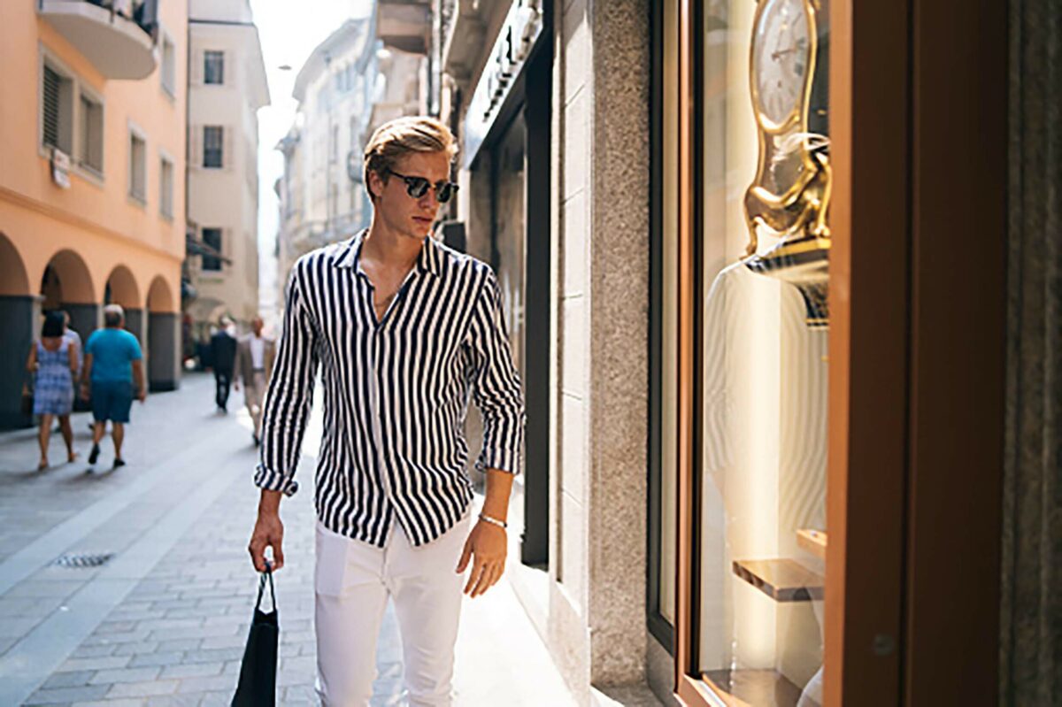 Mann mit Sonnenbrille geht auf Luxuseinkauf
