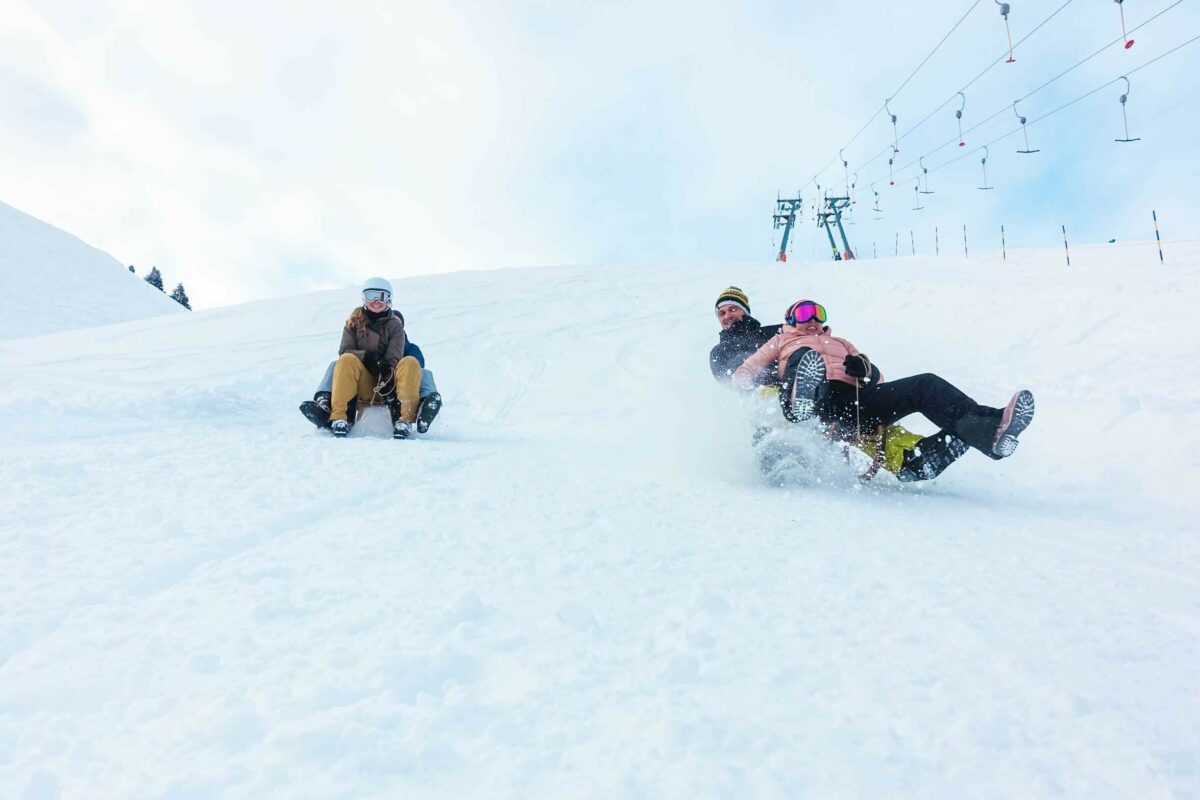 A group of people tobogganing down a mountain