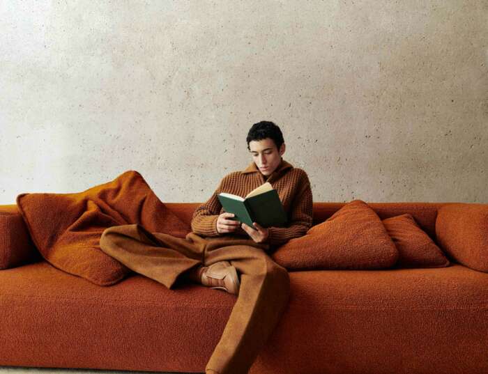A man reading a book on a sofa