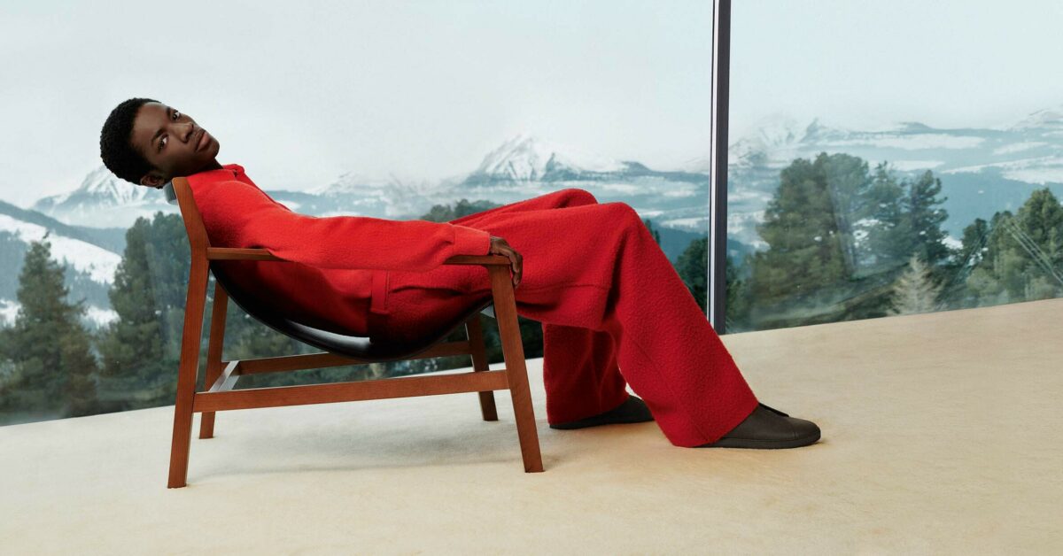A man in a red suit lounging in a chair 