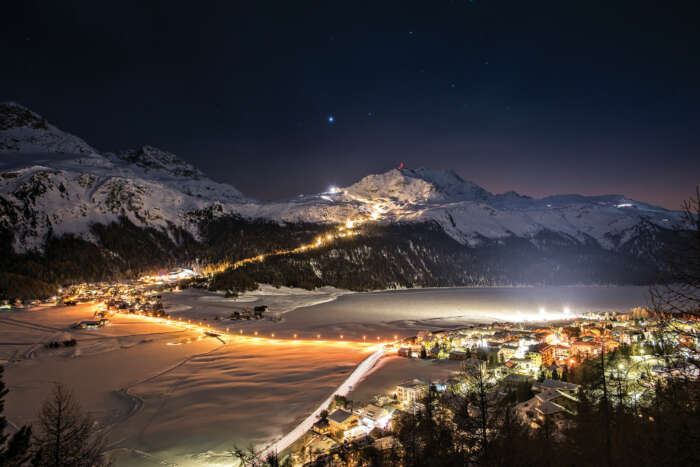 View of floodlit ski piste at night