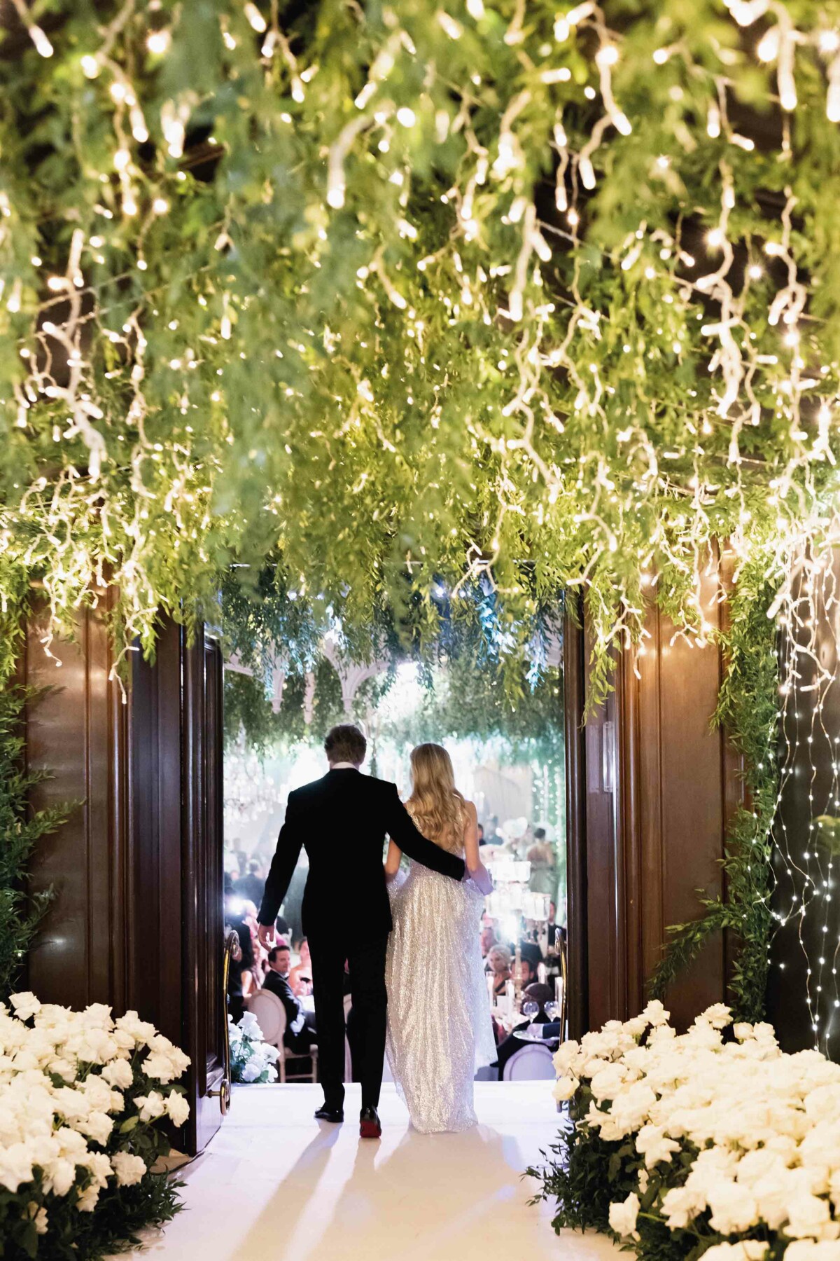 A married couple walking down a grand hallway 