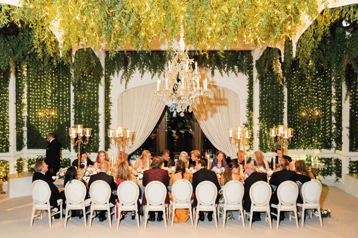 Menschen unterhalten sich am obersten Tisch einer Hochzeit